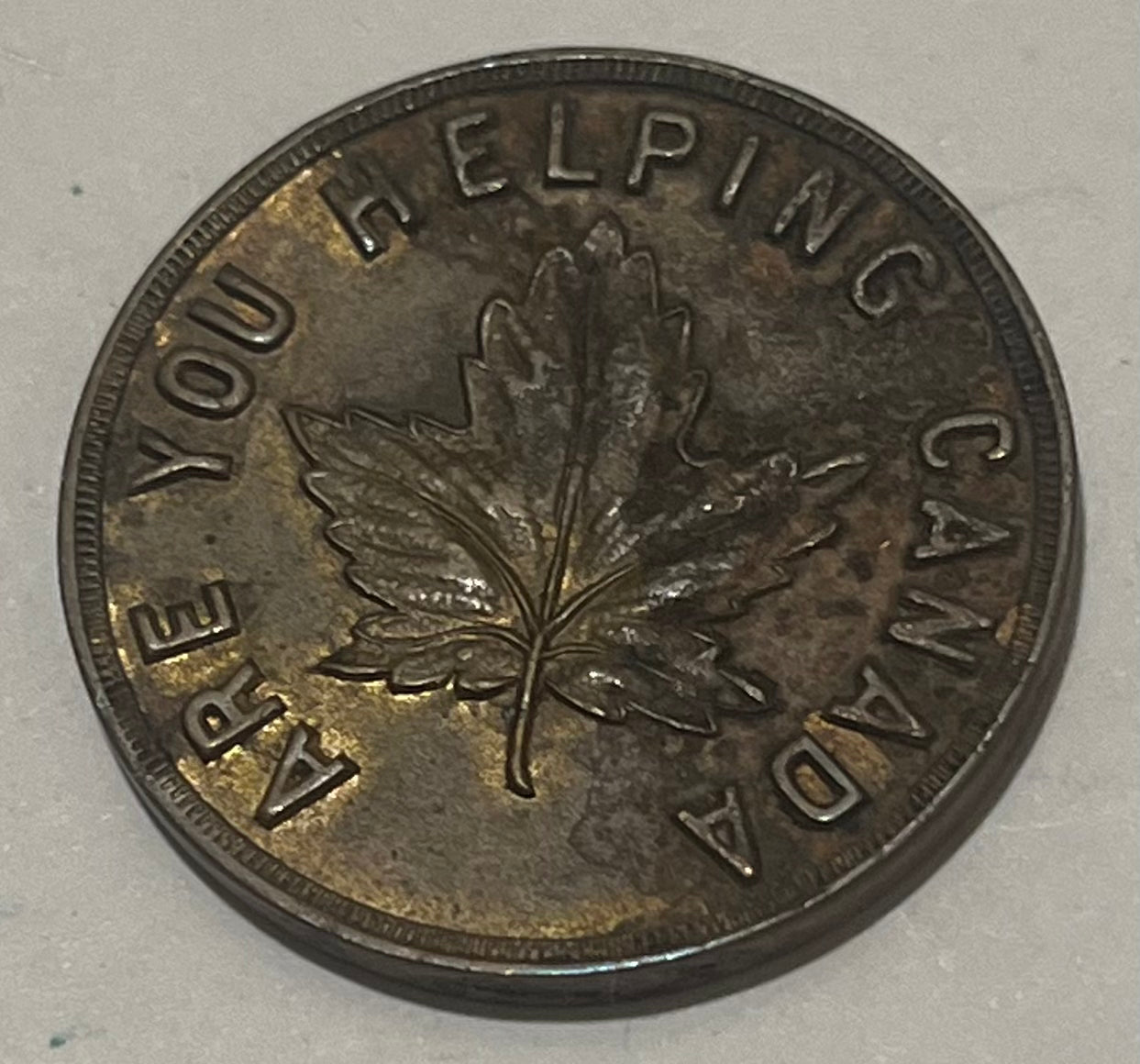 CANADA, W.H. Wilkerson ~ ND WWI era ~ Patriotic token 27mm brass ~ Arms 'Jewelry Diamonds Souvernirs W.H. Wilkerson 915 Government St. Victoria B.C.' ~ 'Are you helping Canada' around maple leaf ~ Unlisted? ~ EF