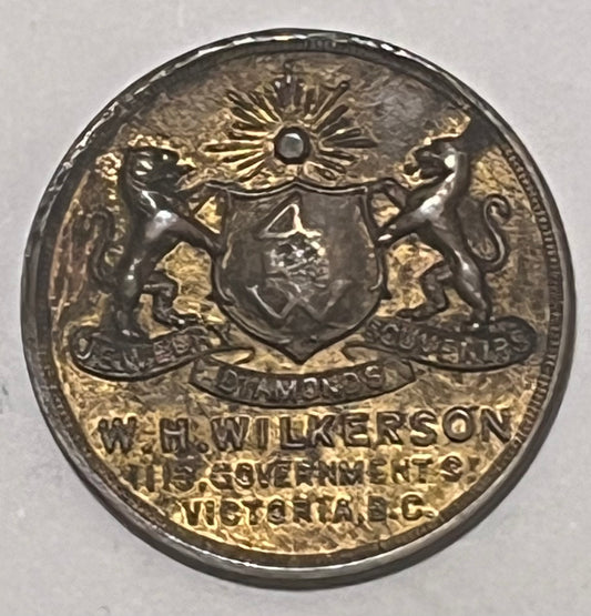 CANADA, W.H. Wilkerson ~ ND WWI era ~ Patriotic token 27mm brass ~ Arms 'Jewelry Diamonds Souvernirs W.H. Wilkerson 915 Government St. Victoria B.C.' ~ 'Are you helping Canada' around maple leaf ~ Unlisted? ~ EF