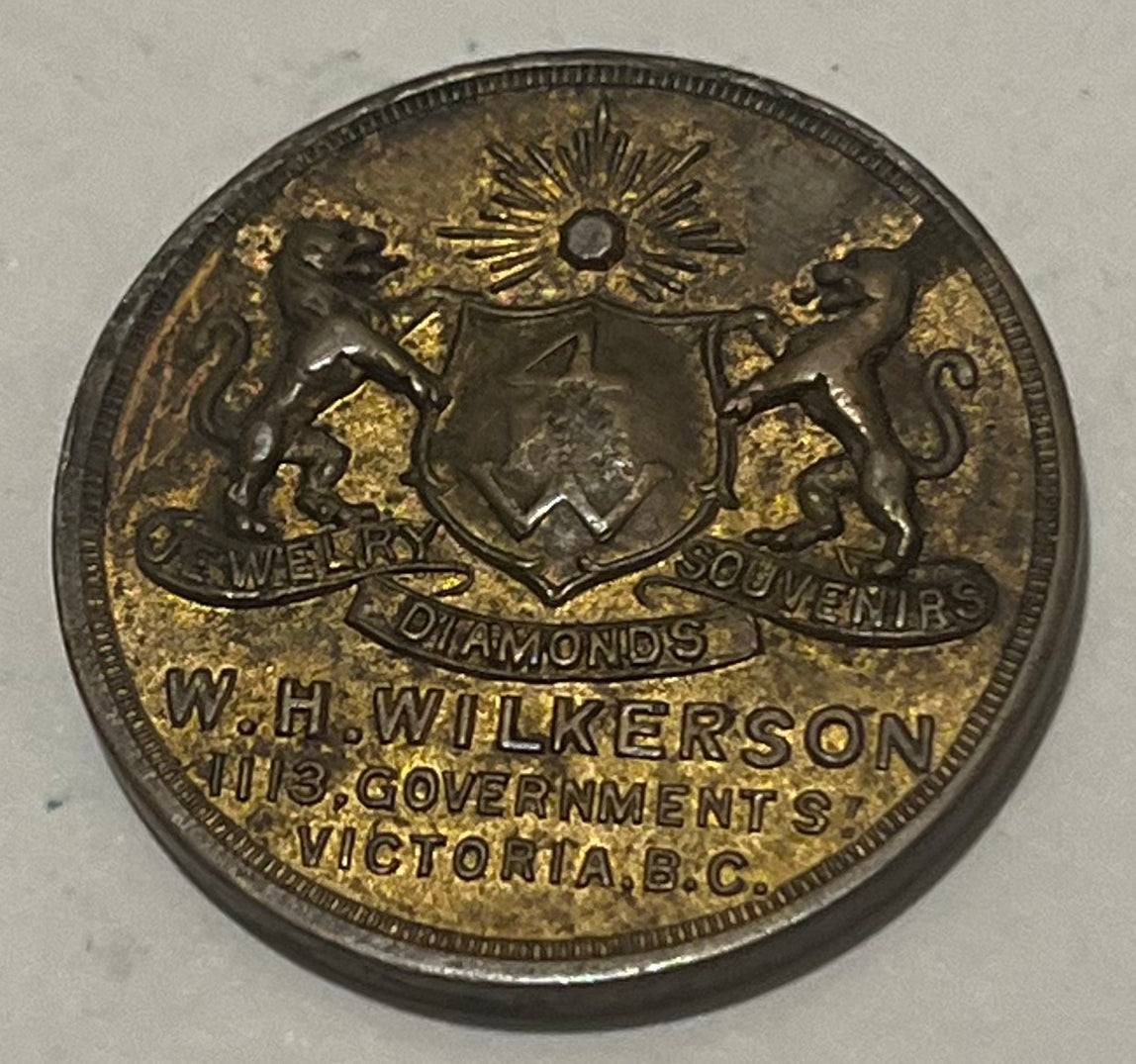 CANADA, W.H. Wilkerson ~ ND WWI era ~ Patriotic token 27mm brass ~ Arms 'Jewelry Diamonds Souvernirs W.H. Wilkerson 915 Government St. Victoria B.C.' ~ 'Are you helping Canada' around maple leaf ~ Unlisted? ~ EF
