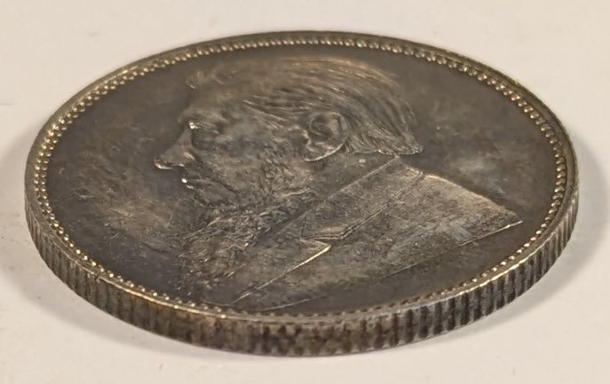 SOUTH AFRICA, Zuid Afrikaansche Republik ~ 1897 ~ Shilling ~ Bust of Paul Kruger left ~ Value divides date in wreath, Z. AFRIK. REP. above.  ~ Y-4, KM-5 ~ Nice unc., a few marks