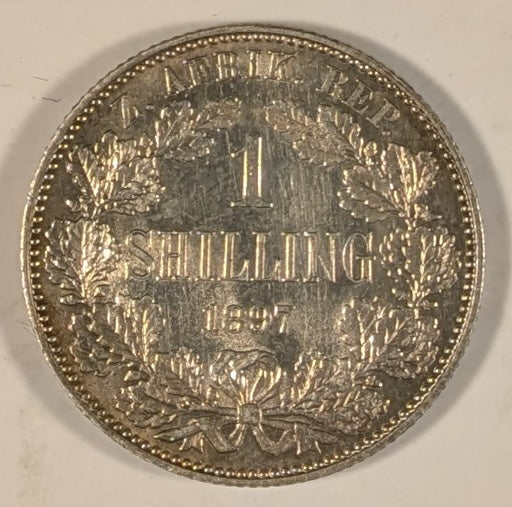 SOUTH AFRICA, Zuid Afrikaansche Republik ~ 1897 ~ Shilling ~ Bust of Paul Kruger left ~ Value divides date in wreath, Z. AFRIK. REP. above.  ~ Y-4, KM-5 ~ Nice unc., a few marks